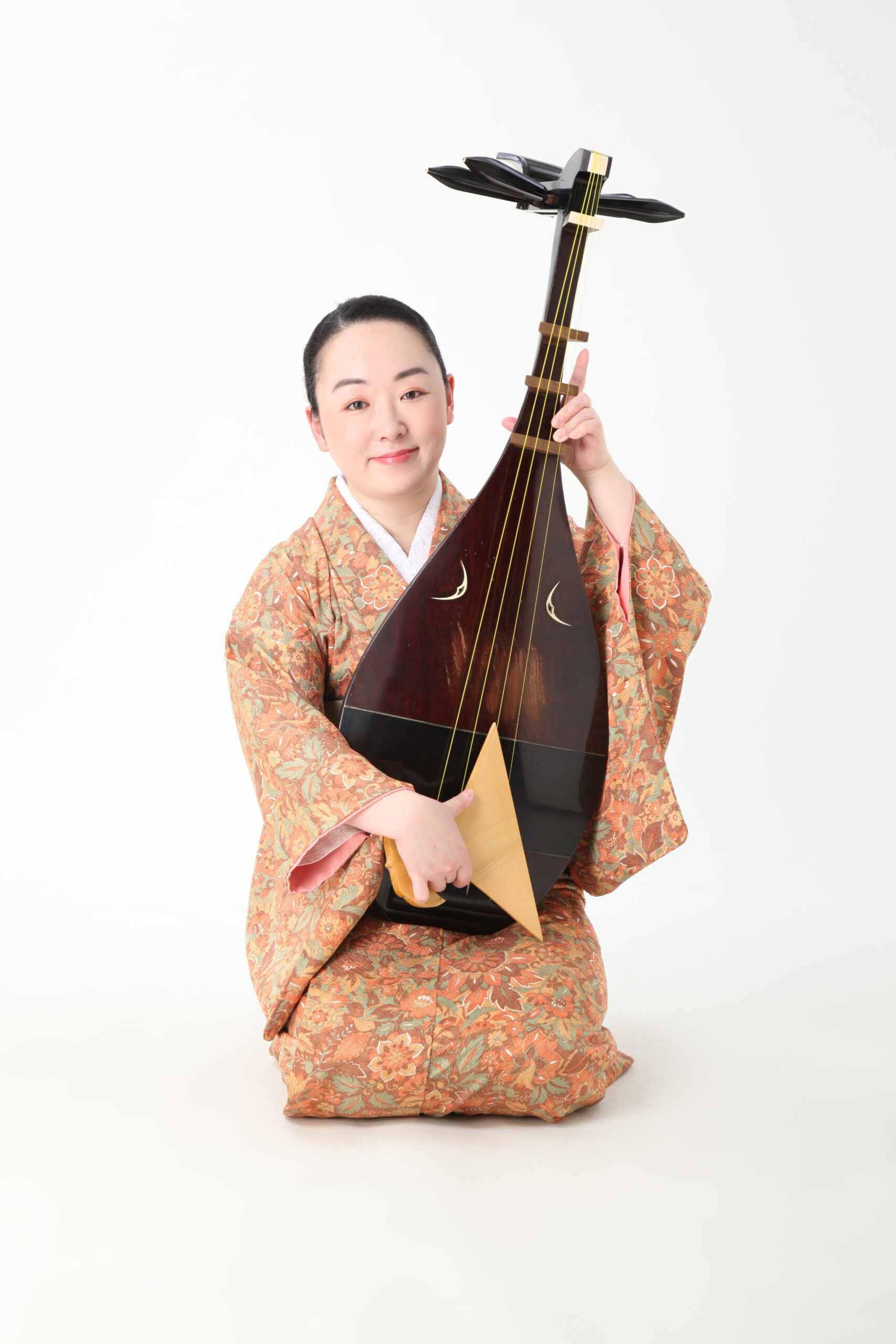 a photo of Hakusui Ogiyama kneeling in kimono and holding a biwa