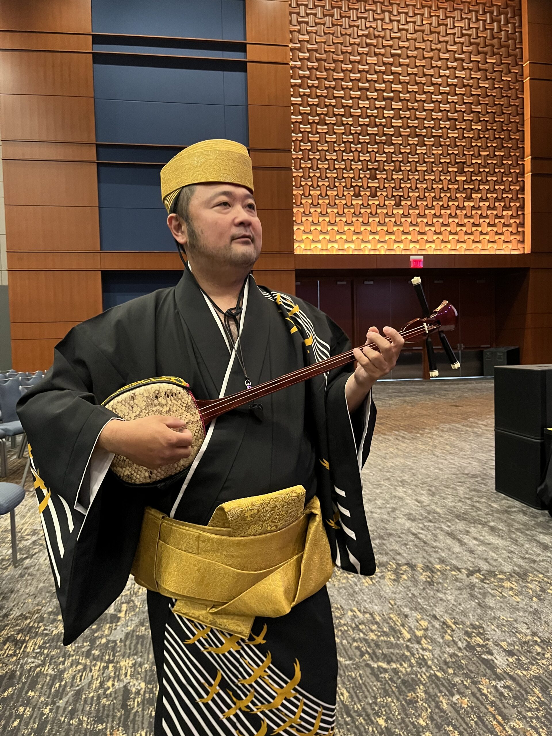 Kaizan Nitta wearing traditional Japanese clothing and playing a sanshin