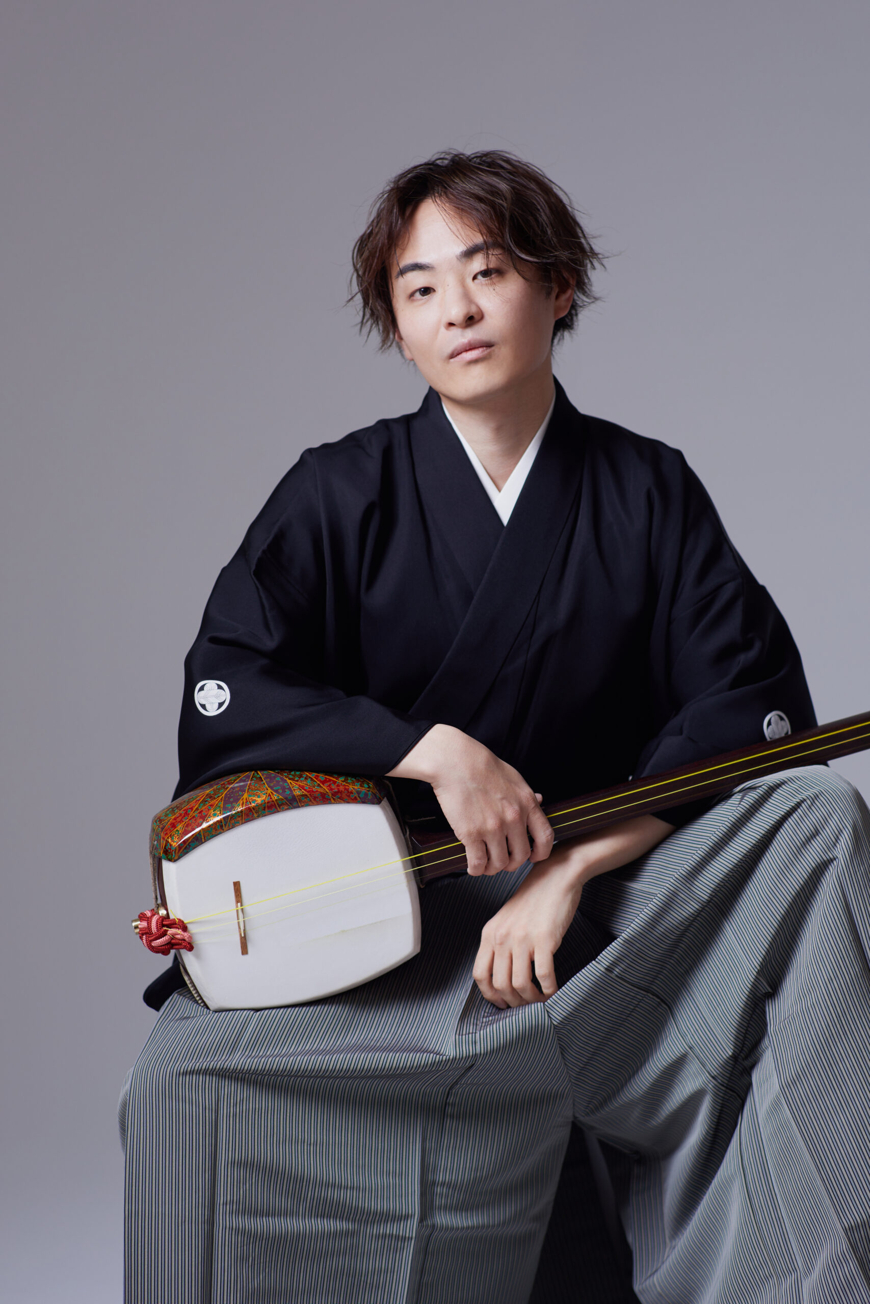 a photo of Sho Asano holding a shamisen