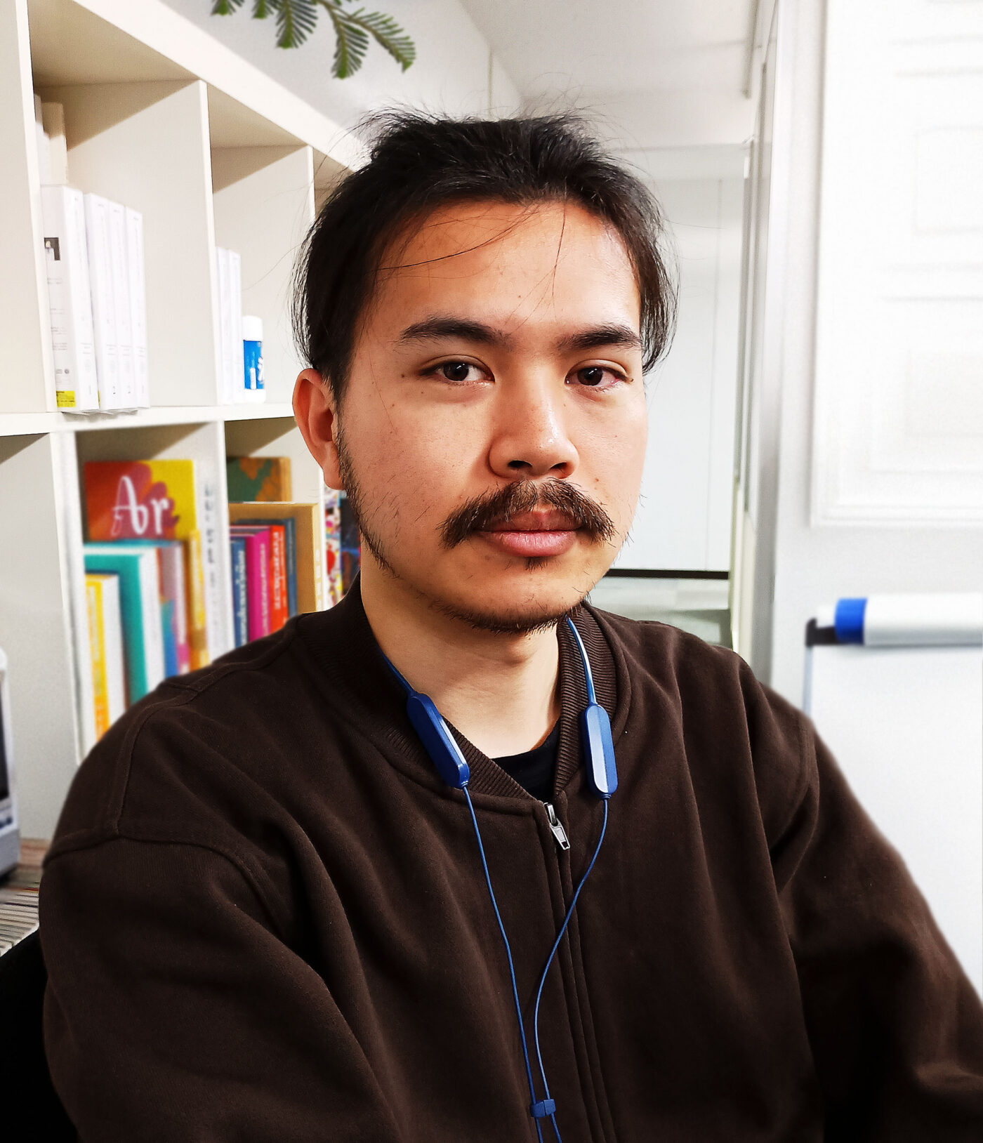 a photograph of Koki Endo seated in front of a book shelf